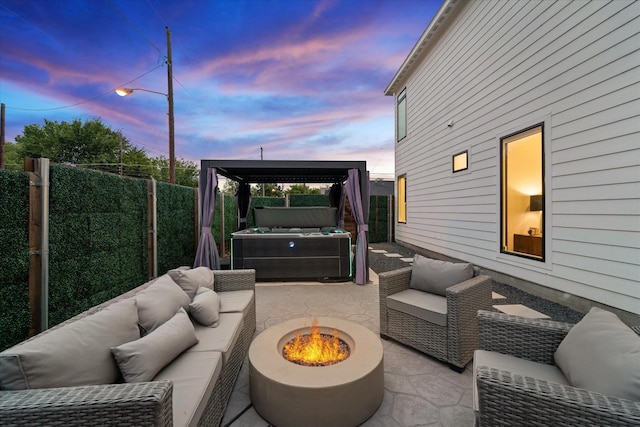 patio terrace at dusk with an outdoor living space with a fire pit