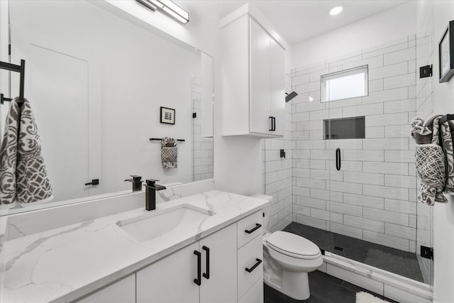 bathroom with tile patterned floors, a shower with door, vanity, and toilet