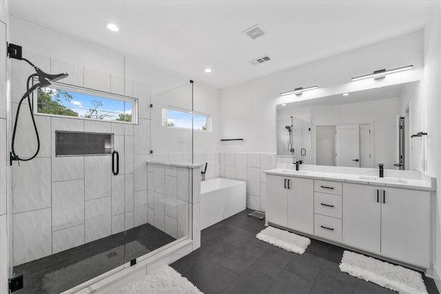 bathroom featuring tile patterned floors, vanity, shower with separate bathtub, and tile walls