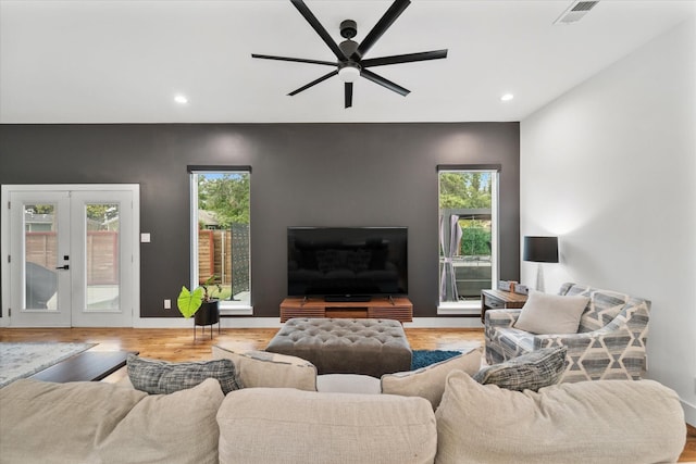 living room with ceiling fan, light hardwood / wood-style floors, and french doors