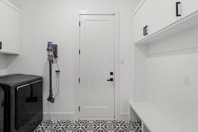 laundry room featuring light tile patterned flooring, cabinets, and washer / dryer