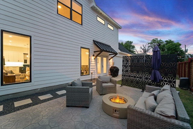 patio terrace at dusk featuring an outdoor living space with a fire pit