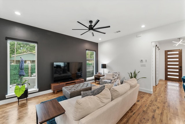 living room with ceiling fan and light hardwood / wood-style floors