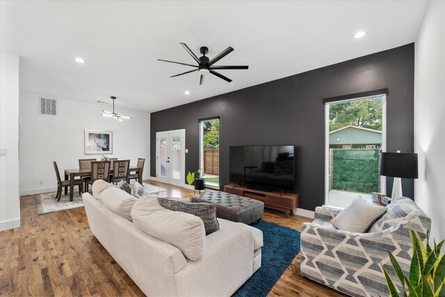 living room with ceiling fan, a healthy amount of sunlight, wood-type flooring, and french doors