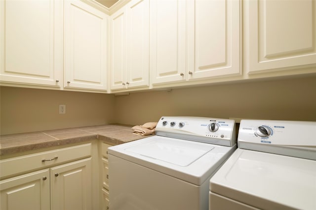 washroom with cabinets and washing machine and clothes dryer