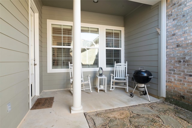 view of patio featuring a porch and a grill