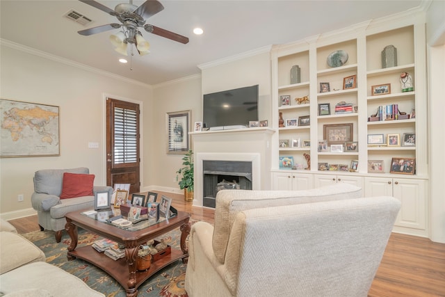 living room featuring ceiling fan, ornamental molding, and light hardwood / wood-style flooring