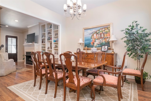 dining room with a notable chandelier, wood-type flooring, and ornamental molding