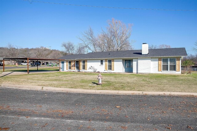 ranch-style house with a front yard and a carport