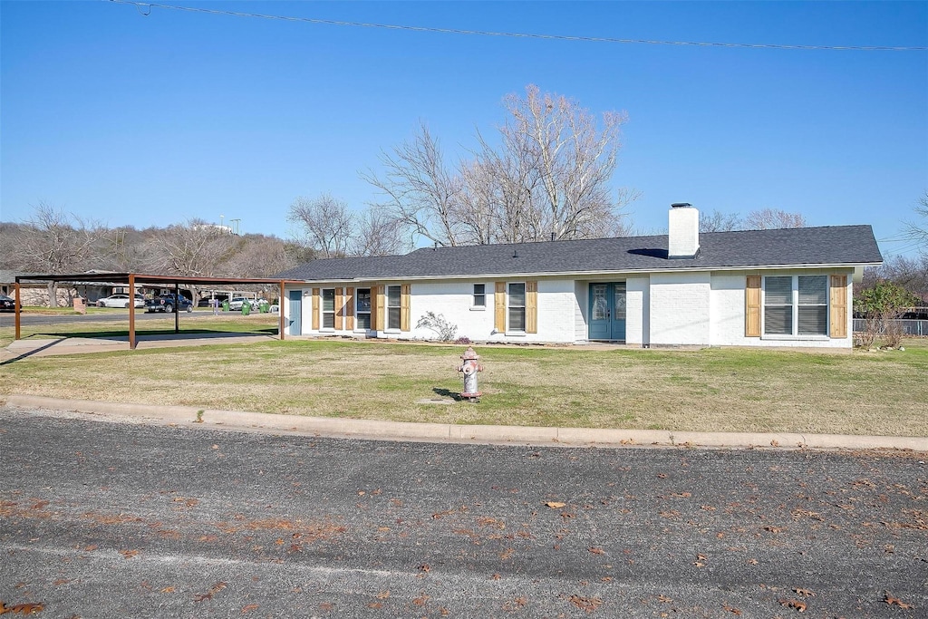 ranch-style house with a front yard and a carport