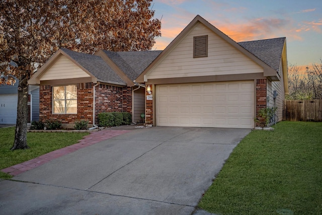 ranch-style home featuring a garage and a lawn