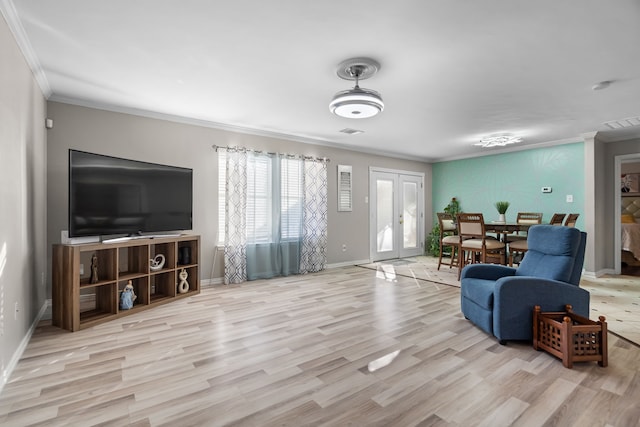 living room with french doors, crown molding, and light wood-type flooring