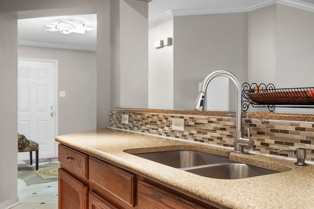 kitchen with crown molding, sink, and tasteful backsplash