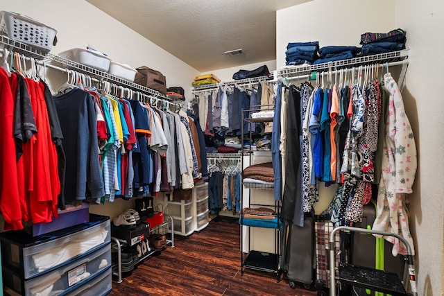 walk in closet with dark hardwood / wood-style flooring