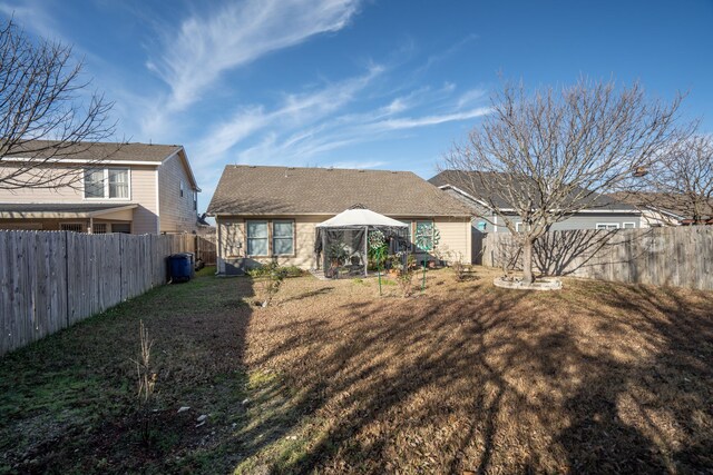 rear view of property with a gazebo and a lawn