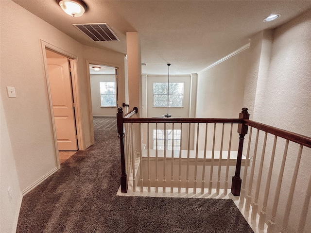 corridor featuring dark colored carpet