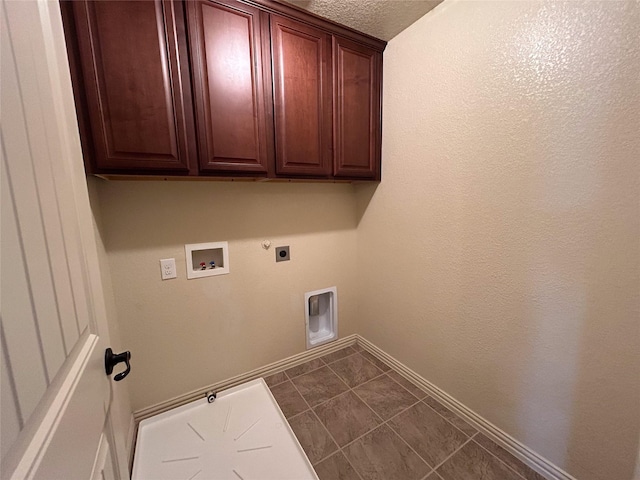 laundry room with dark tile patterned flooring, cabinets, hookup for a gas dryer, hookup for a washing machine, and hookup for an electric dryer