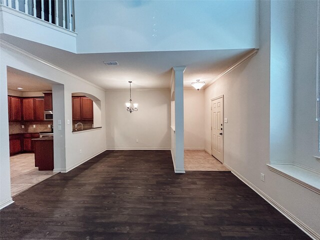 foyer entrance featuring dark hardwood / wood-style flooring, crown molding, and a notable chandelier