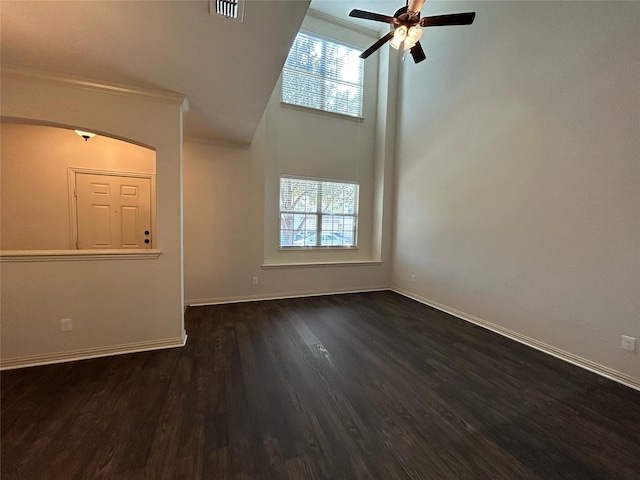 unfurnished living room featuring ceiling fan, dark hardwood / wood-style floors, and a towering ceiling