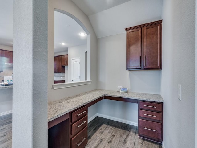 office space featuring built in desk, dark hardwood / wood-style floors, and lofted ceiling