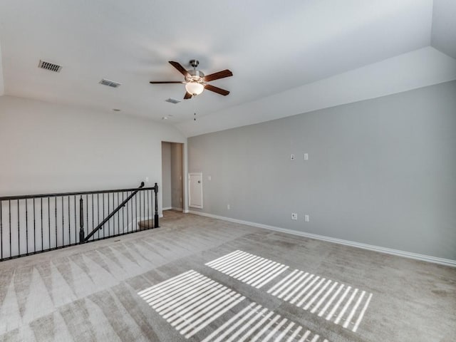 unfurnished room featuring light colored carpet, vaulted ceiling, and ceiling fan