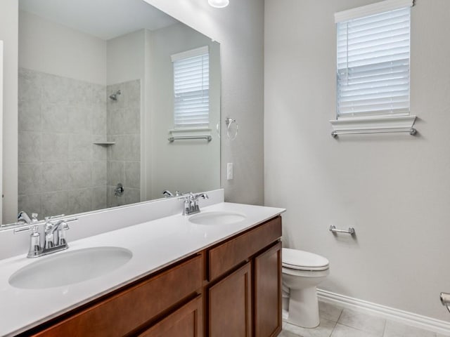 bathroom featuring tile patterned floors, vanity, tiled shower, and toilet