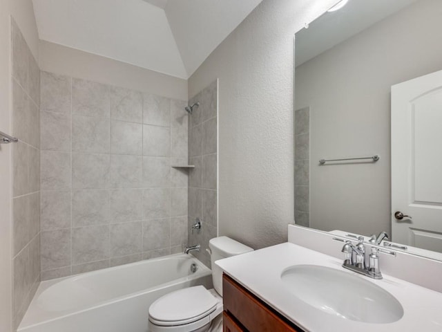 full bathroom featuring vanity, tiled shower / bath combo, toilet, and vaulted ceiling