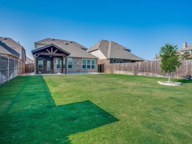 back of property with ceiling fan and a yard