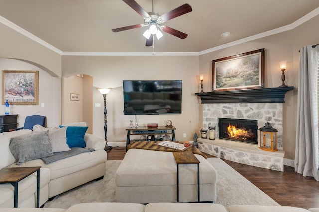 living room featuring a fireplace, crown molding, and wood-type flooring