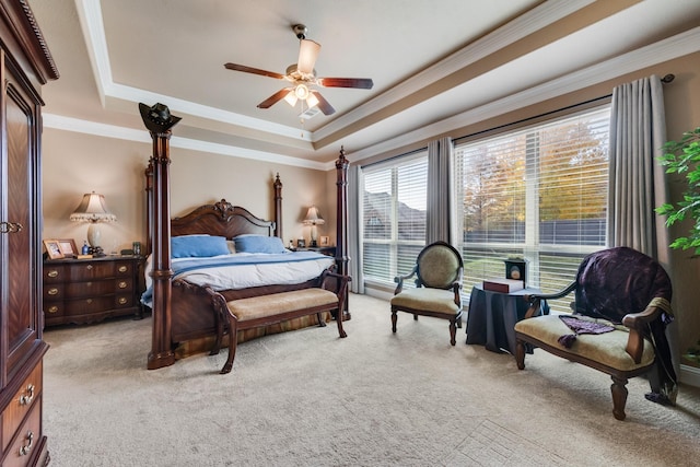 bedroom featuring a raised ceiling, ornamental molding, light colored carpet, and ceiling fan