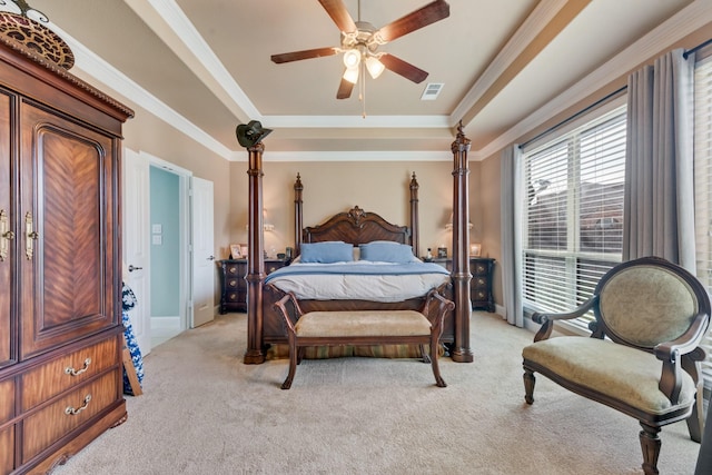 bedroom featuring crown molding, a raised ceiling, and light carpet