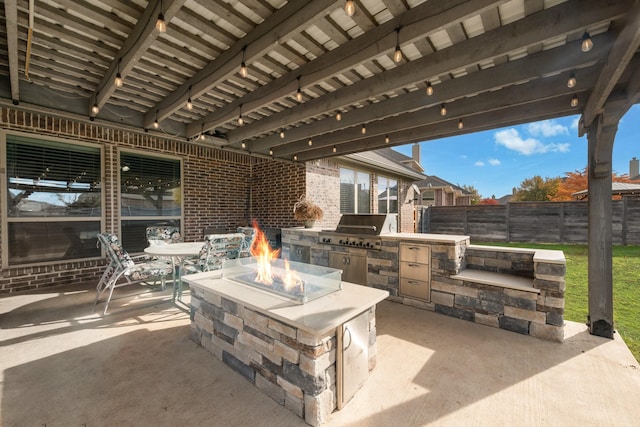 view of patio with grilling area, an outdoor fire pit, and exterior kitchen