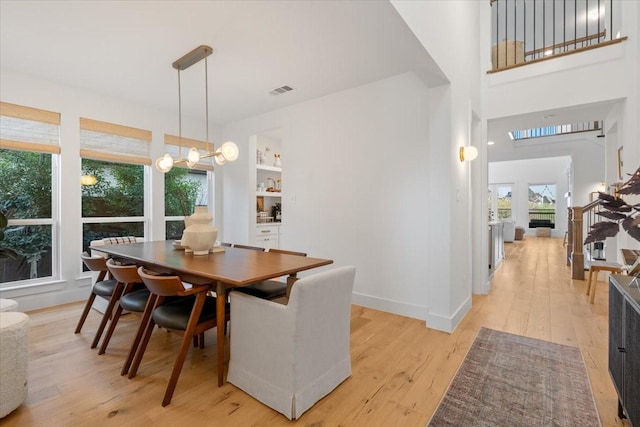 dining area with built in shelves and light wood-type flooring