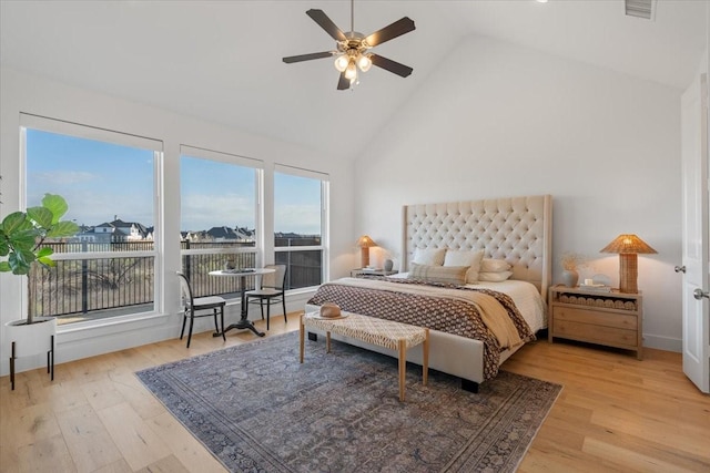 bedroom with light wood-type flooring, high vaulted ceiling, and ceiling fan