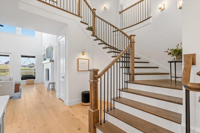 stairs featuring hardwood / wood-style flooring and a high ceiling