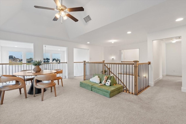 living area featuring ceiling fan, light carpet, and vaulted ceiling