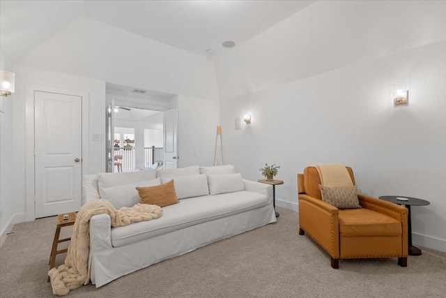 carpeted living room with ceiling fan and vaulted ceiling