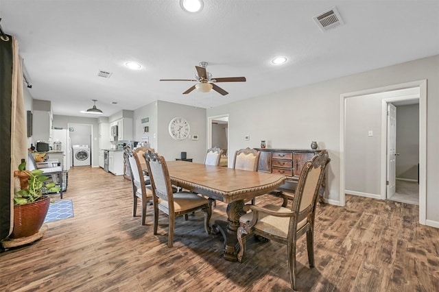 dining room featuring hardwood / wood-style flooring, ceiling fan, and washer / dryer