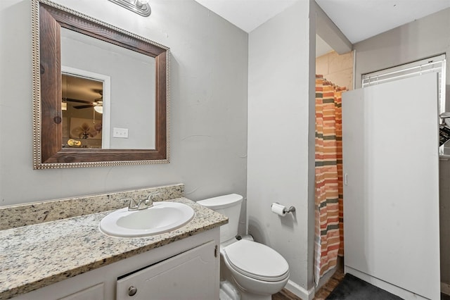 bathroom featuring vanity, ceiling fan, toilet, and curtained shower