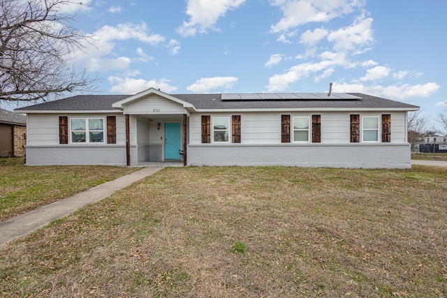 ranch-style house with a front yard and solar panels