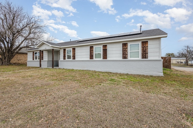 single story home with solar panels and a front yard