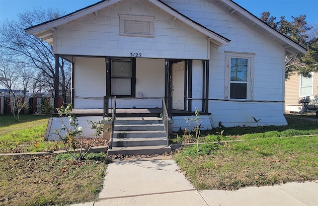 bungalow-style home featuring covered porch and a front yard