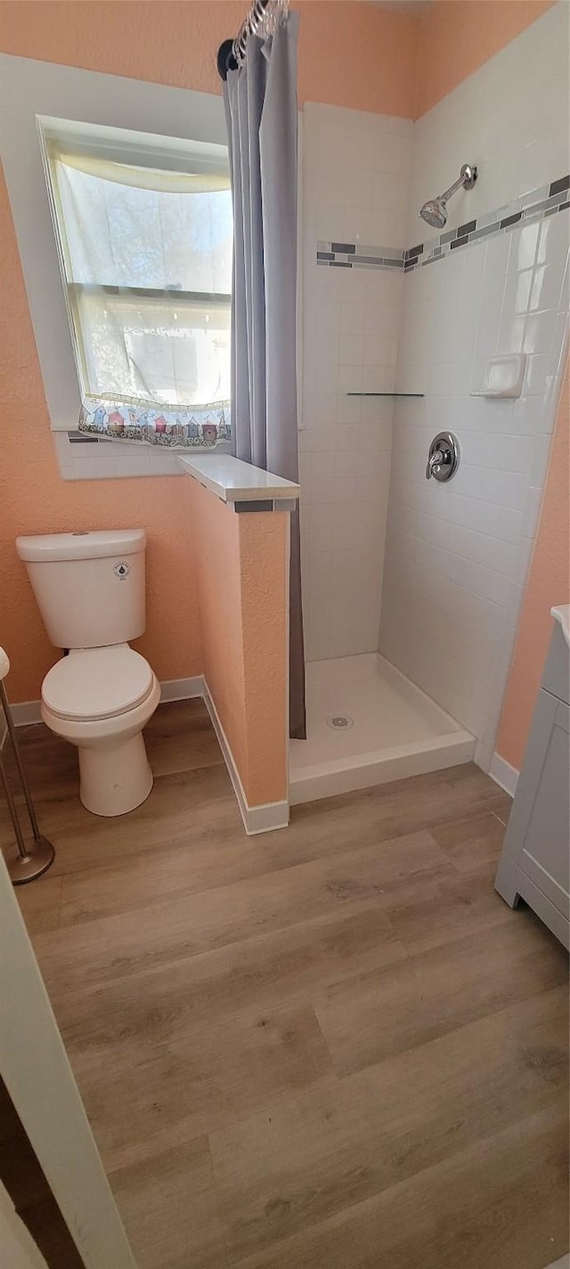 bathroom featuring hardwood / wood-style flooring, a shower with curtain, and toilet