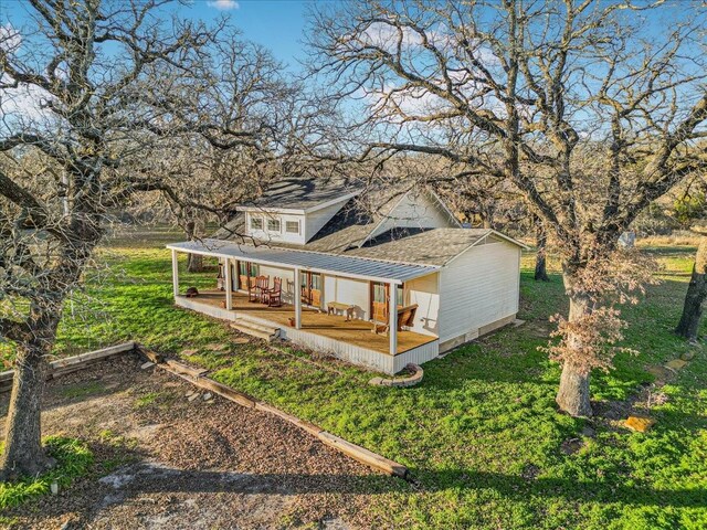 back of house featuring a porch and a yard