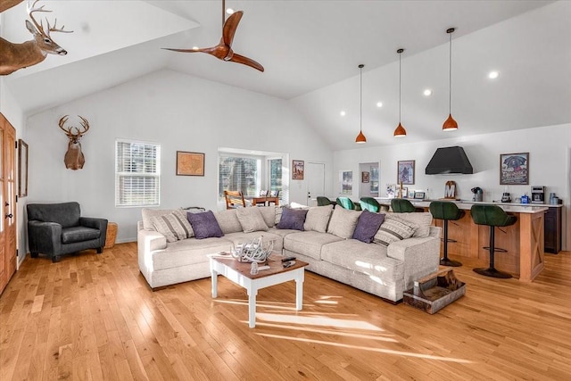 living room with ceiling fan, high vaulted ceiling, and light hardwood / wood-style floors