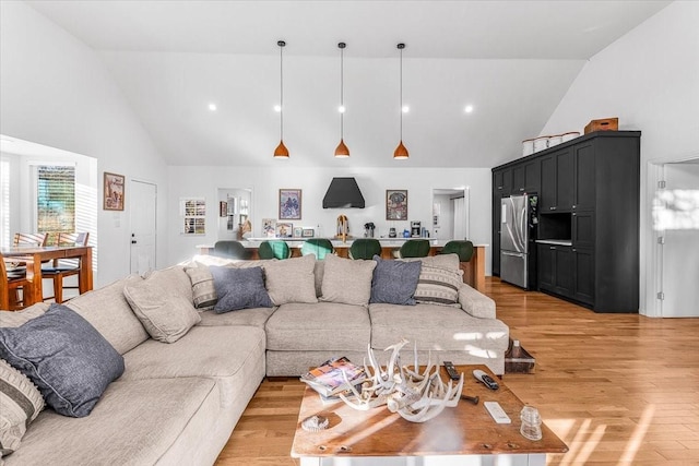 living room with high vaulted ceiling and light hardwood / wood-style floors