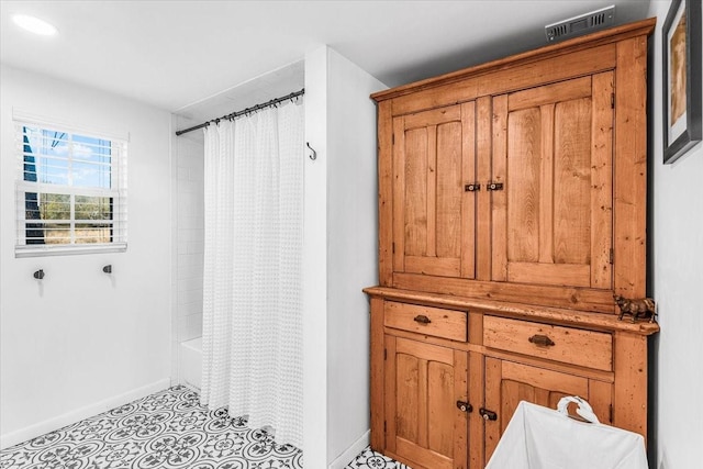 bathroom with tile patterned flooring and shower / tub combo with curtain