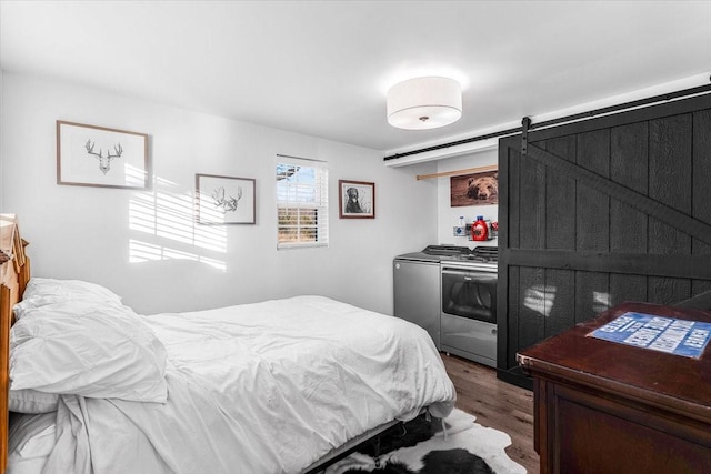 bedroom featuring a barn door and dark hardwood / wood-style flooring