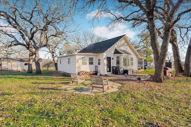 rear view of house with a patio and a yard