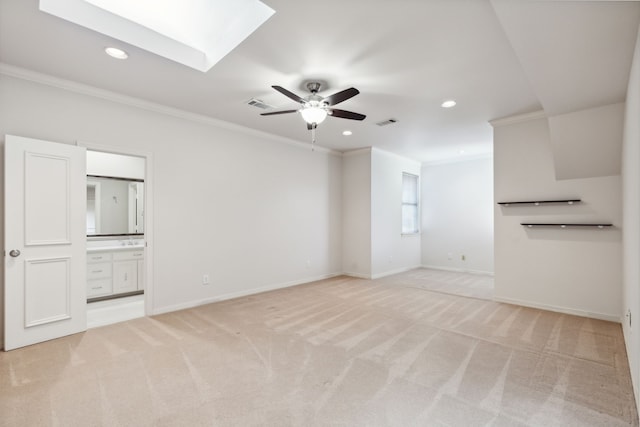 unfurnished living room with light carpet, a skylight, and crown molding